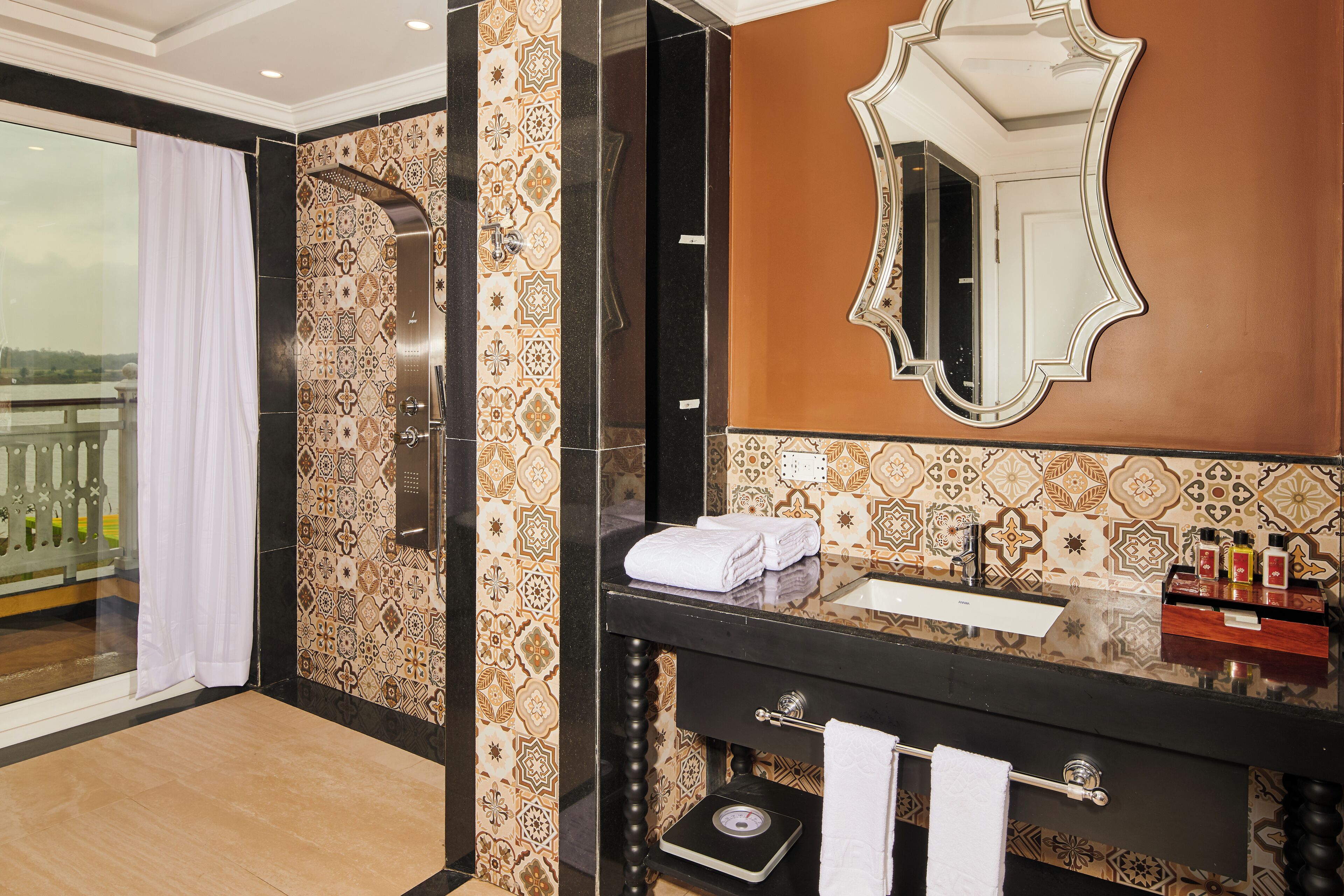 A bathroom with a large mirror, a sink, and a towel rack.