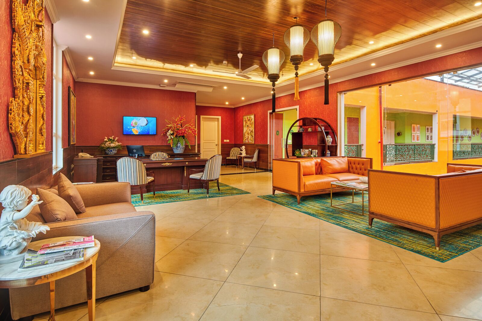 A spacious lobby with a reception desk, seating area, and a television.