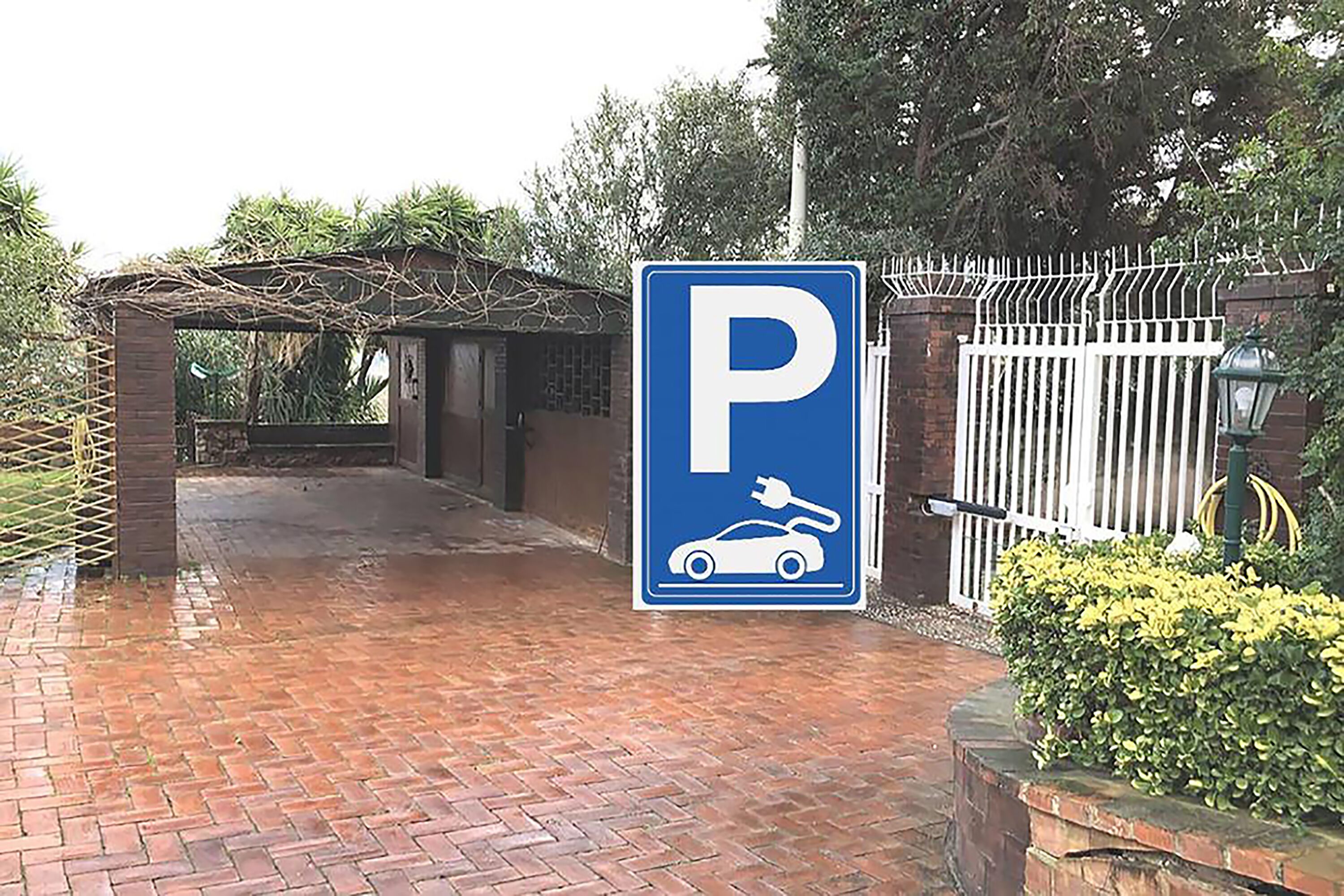 A parking sign with a car and plug symbol, indicating electric vehicle charging.