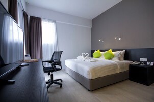 Ein Hotelzimmer mit Bett, Schreibtisch, Stuhl und Nachttisch.