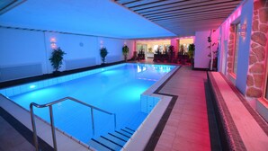 An indoor swimming pool with clear water, surrounded by stone walls and wooden beams. - Wellness Hotel Garni Krone (Baiersbronn)