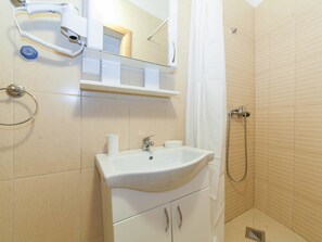 Standaard appartement, uitzicht op stad | Badkamer | Een douche, een haardroger, pantoffels, handdoeken