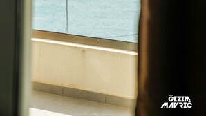 A view from a window with a curtain, overlooking a calm sea and a rocky outcrop. - HOTEL MEDITERRANEO LIMAN free private beach for hotel guest (Ulcinj)