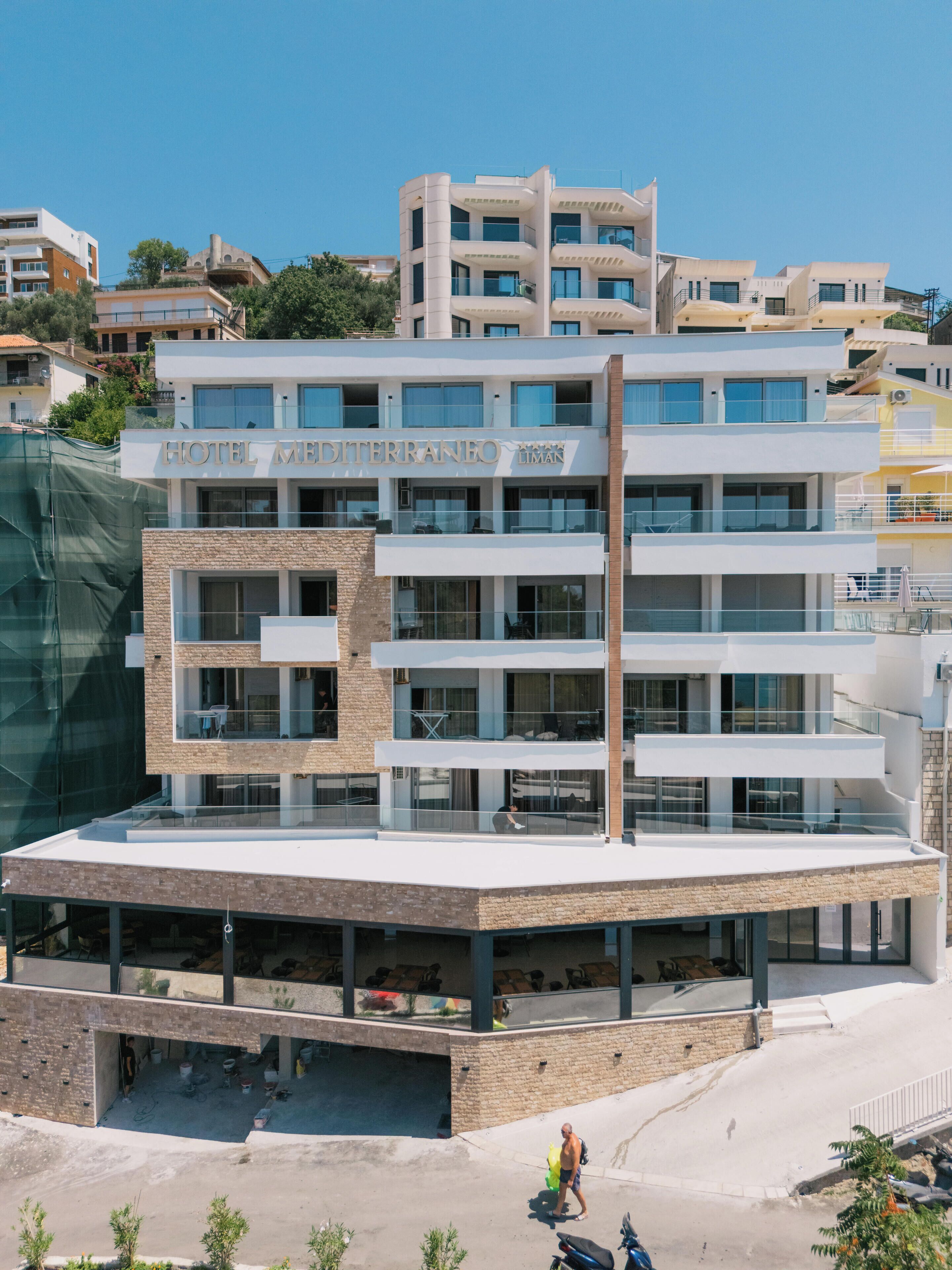 A modern hotel with multiple floors and balconies, featuring a prominent sign.