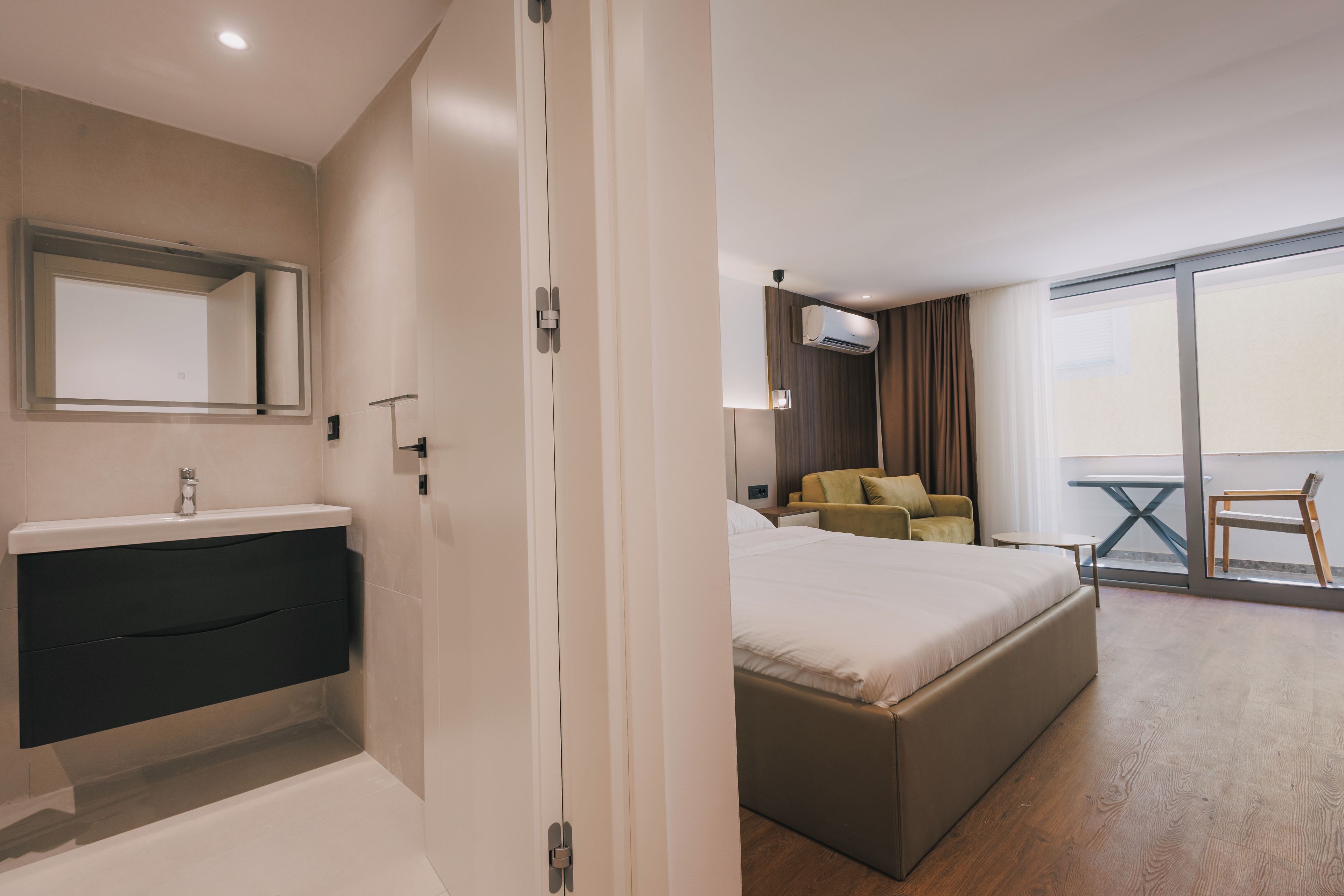Ein Hotelzimmer mit Bad, Bett, Sofa und Balkon.
