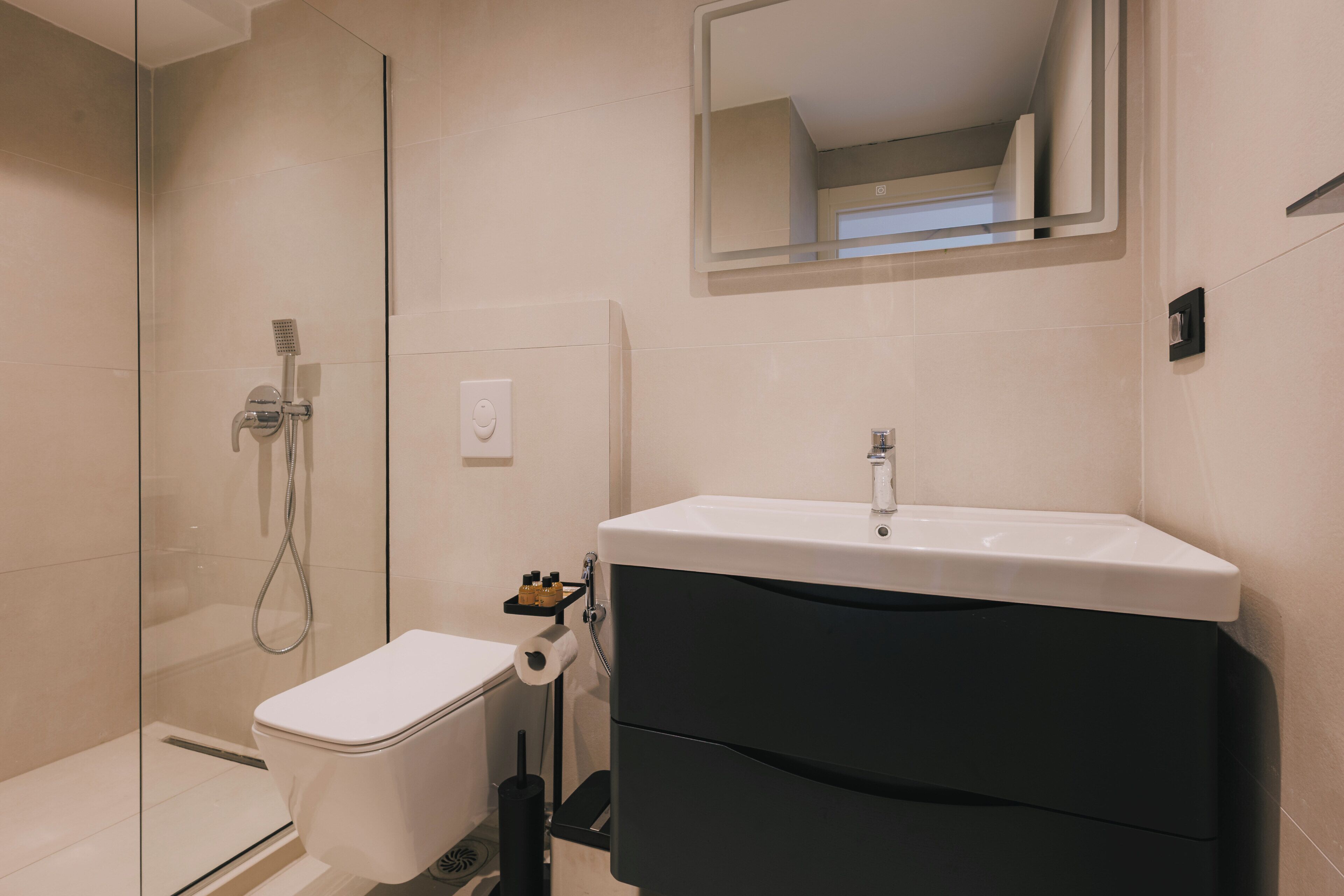 A bathroom with a toilet, a sink, and a shower.
