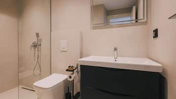 Un baño con inodoro, lavabo y ducha.