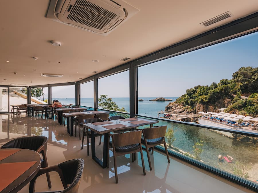 Un comedor moderno con amplios ventanales que dan a la vista del mar.