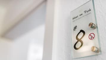 Une porte en verre dotée d’un clavier à code et d’un panneau indiquant qu’il est interdit de fumer.