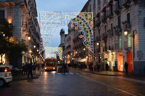 Una calle con patrones geométricos iluminados sobre ella, un autobús en el centro y edificios a ambos lados.