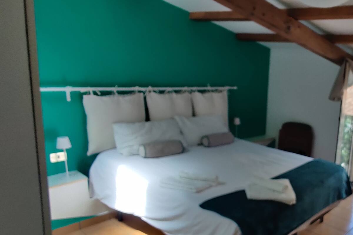 Una camera da letto con un letto, una televisione e una finestra con tende.
