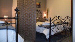 A bedroom with two beds, a brick wall, a painting, and a lamp. - Luxury Catania (Catania)