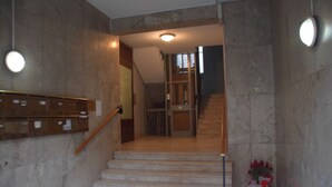 A staircase with marble walls and a wooden handrail leading to an upper floor. - Luxury Catania (Catania)