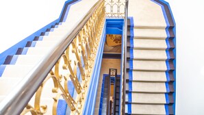 Eine Treppe mit blauer und goldener Geländer, die zu einer Ebene hinabführt.
