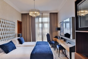 A hotel room with a large bed, a desk, a chair, and a television. - Casual Belle Epoque Lisboa Hotel by Casual Hoteles (Lisbon)
