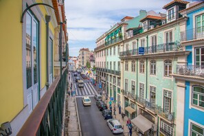 A street view with colorful buildings, parked cars, and pedestrians. - Casual Belle Epoque Lisboa Hotel by Casual Hoteles (Lisbon)