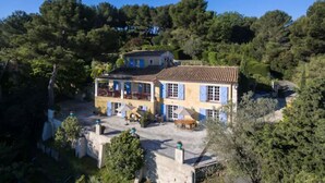 A two-story house with a tiled roof, surrounded by dense trees. - Villa Le Port d'Attache (Cannes)