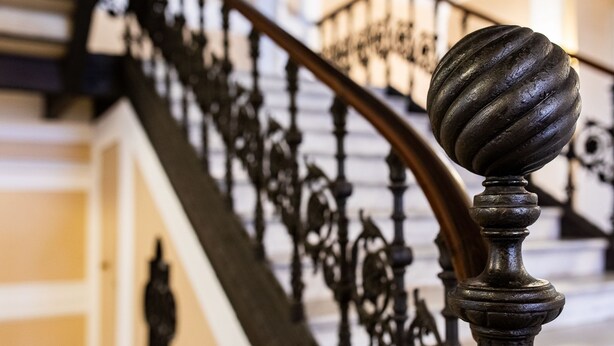 A staircase with ornate black balusters and a round, textured balustrade. - Hotel Youri Il Magnifico (Genoa)