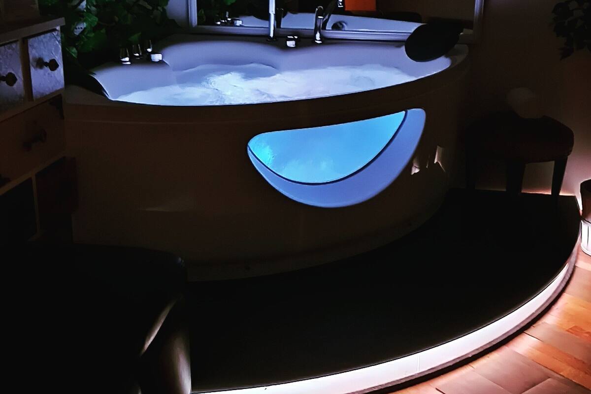 A modern bathroom with a freestanding bathtub, a mirror, and a sink.