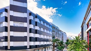 Een meerlaags hotel met een modern architectuurontwerp, met een reeks balkons en grote ramen.
