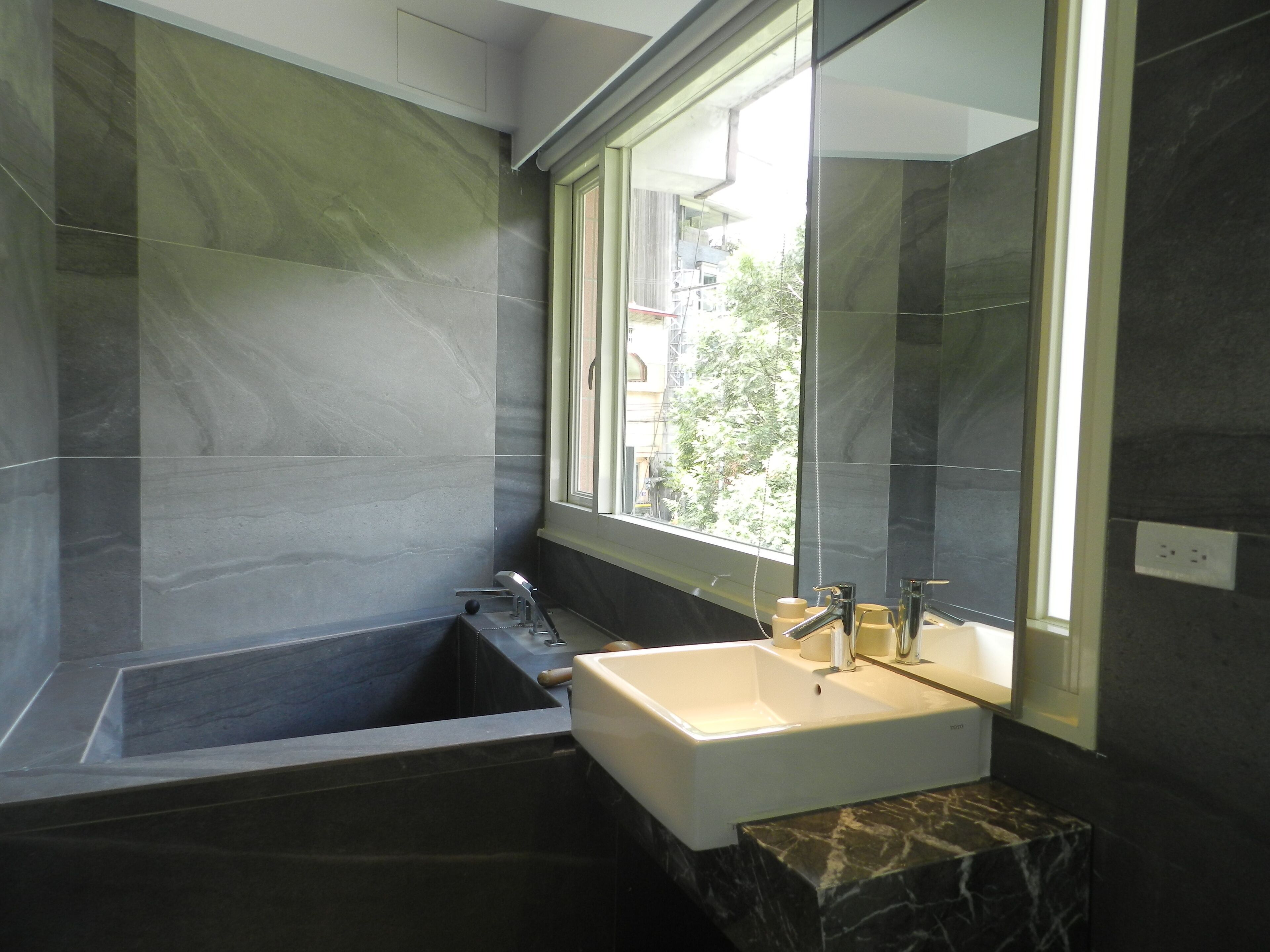 Ein modernes Badezimmer mit Badewanne, Waschbecken und einem großen Spiegel.