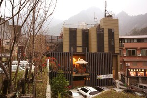 A modern building with a balcony, a staircase, and a signboard.
