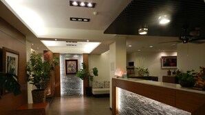 Eine Hotellobby mit Empfangstresen, Sitzgelegenheiten und einer Wand mit Steinverkleidung.