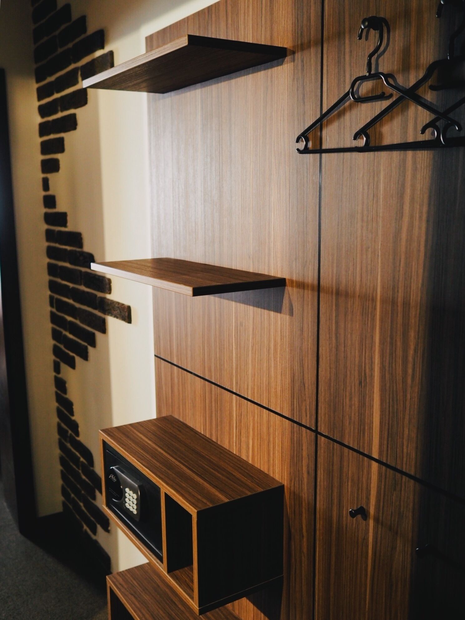 A modern wardrobe with multiple wooden shelves and a hanging rack.