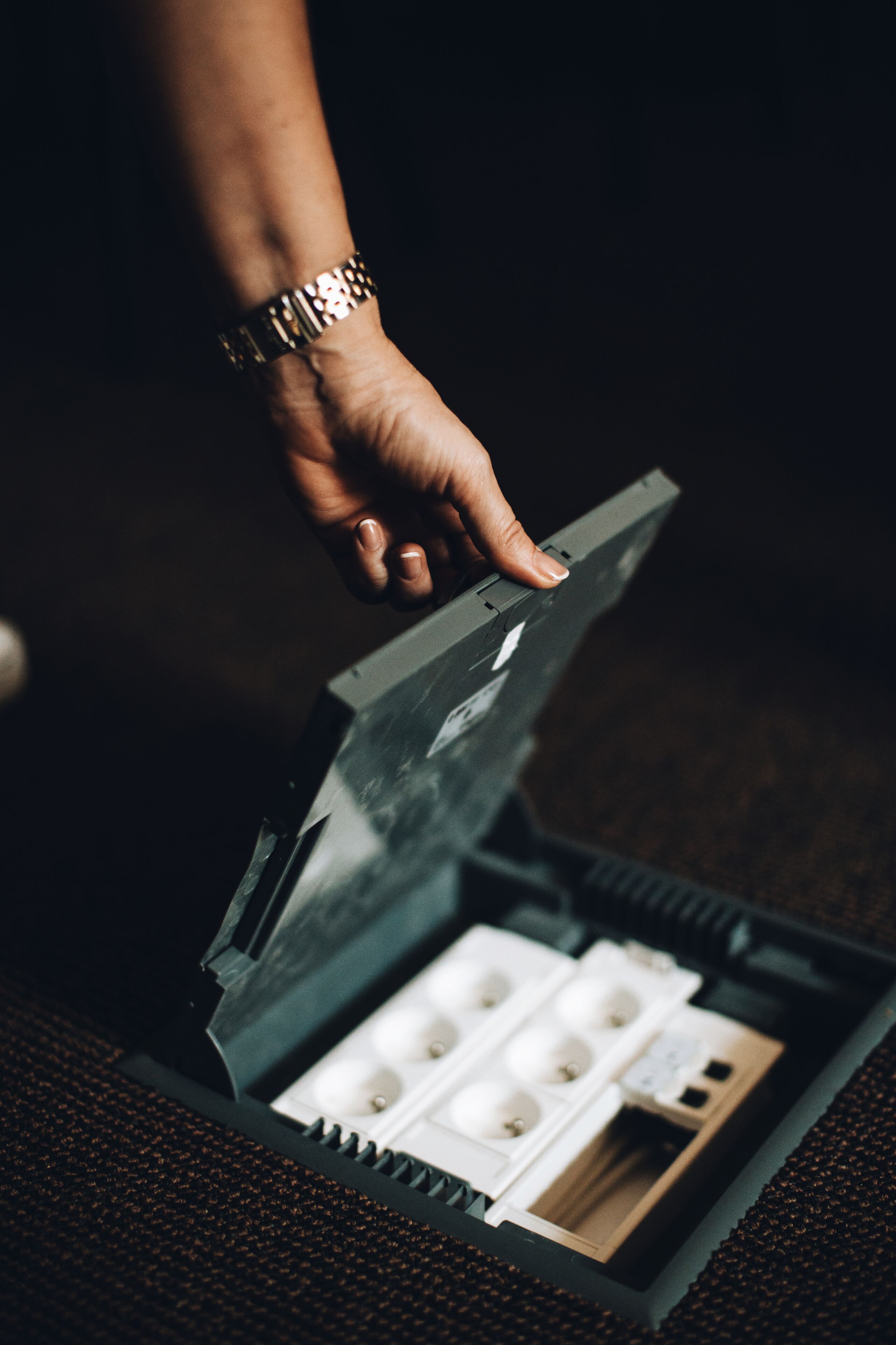 A hand opening a box containing a set of keys and a card.