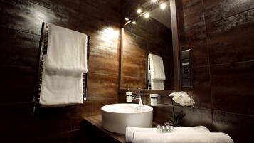 Un baño moderno con un lavamanos grande, un espejo y un perchero para toallas.