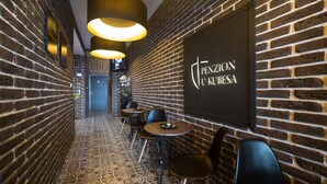 A narrow corridor with brick walls, patterned flooring, and modern lighting fixtures. - Penzion U Kubesa (Kromeriz)