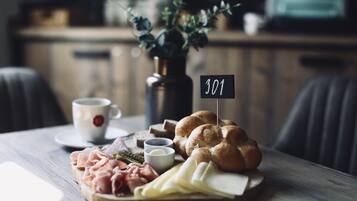 A wooden table with a charcuterie board, a cup of coffee, and a small sign with the number 301.