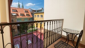 A balcony with a wrought iron railing, a small round table, and a chair. - Penzion U Kubesa (Kromeriz)