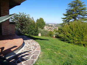 A patio with stone flooring and a view of a town in the distance. - B&B Titty (Montottone)