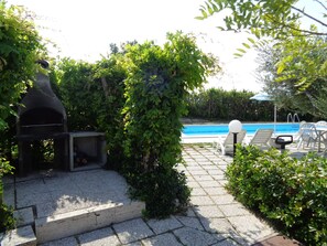 A backyard with a barbecue grill, a swimming pool, and lounge chairs. - B&B Titty (Montottone)