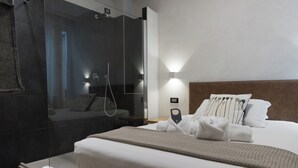 A modern hotel room with a large bed, a glass shower enclosure, and a bedside table with a lamp. - Hotel Doria (Genoa)