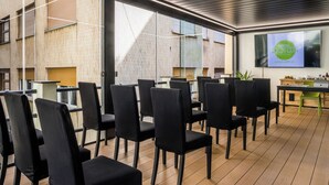 A modern hotel lobby with black chairs arranged for seating, a wooden floor, and a large window providing natural light. - Hotel Doria (Genoa)