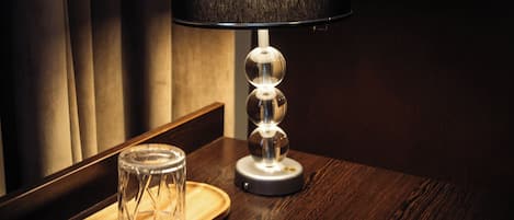 A table with a lamp, a glass container, and a wooden tray.