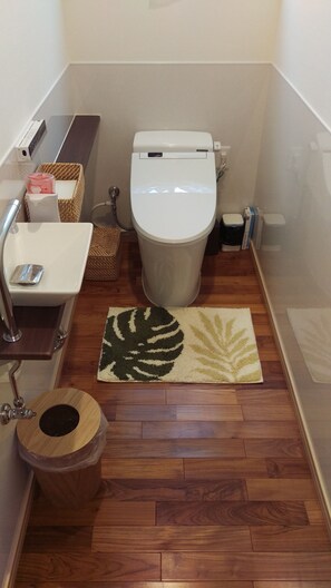 Ein kleines Badezimmer mit Toilette, Waschbecken und Mülleimer.