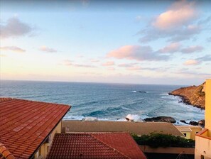 A coastal view with a tiled roof and buildings overlooking the sea. - Blu Bed & Breakfast (Castelsardo)