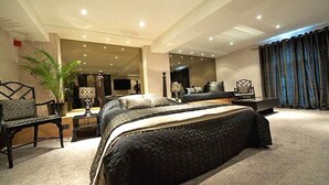 Un dormitorio amplio con una cama grande, un escritorio, una silla y un televisor.