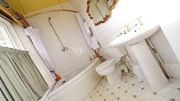 Un bagno con vasca, WC e lavandino.