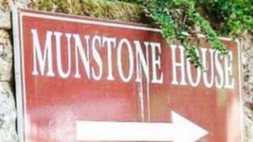 A directional sign for 'MUNSTONE HOUSE' with an arrow pointing to the right.
