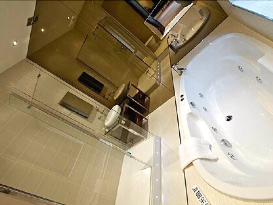 A modern bathroom with a large bathtub, a glass shower enclosure, and a visible toilet.