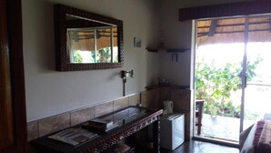A bathroom with a large mirror, a sink, and a shower area. - Caprivi River Lodge (Katima Mulilo)