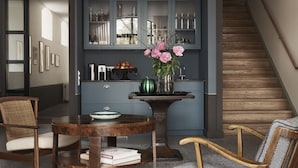 A modern kitchen with a dining area, featuring a wooden table, chairs, and a vase of flowers. - Wanås Restaurant Hotel (Knislinge)