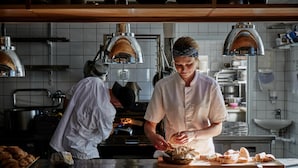 A professional kitchen with stainless steel countertops, a wood-fired oven, and overhead lighting. - Wanås Restaurant Hotel (Knislinge)