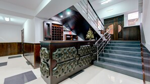 A reception area with a modern design, including a staircase and a Christmas tree. - Catherine Hotel (Chisinau)
