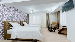 A hotel room with two beds, a sofa, a TV, and a ceiling fan. - Catherine Hotel (Chisinau)