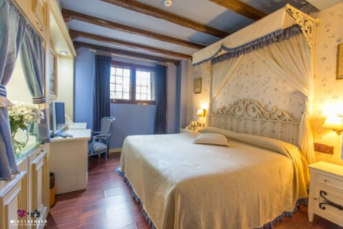 Un dormitorio con una cama grande, un escritorio y una silla.